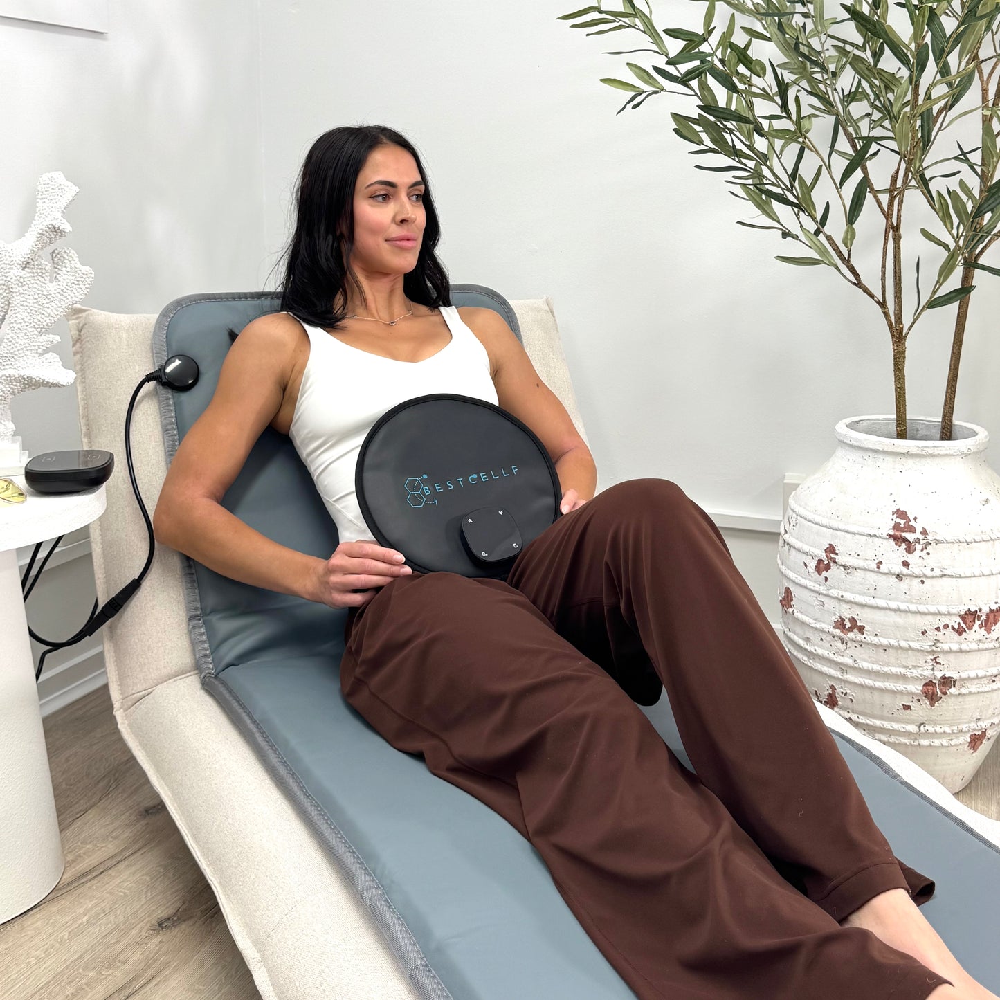 Steph using portable pulsed magnetic field therapy pad on the full body mat