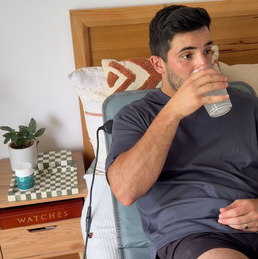 Adrian drinking Mineral Complex+ on BEST CELLF PEMF mat in bedroom