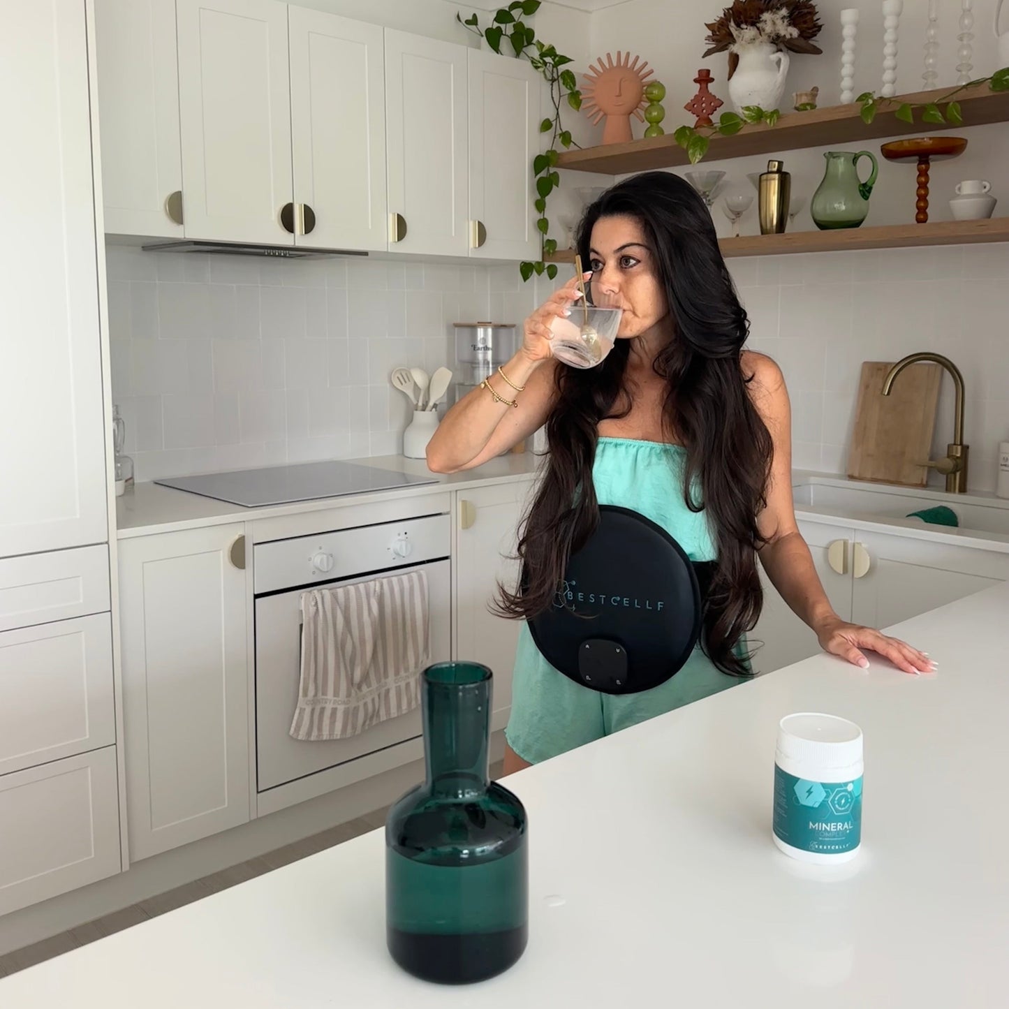 Georgia using the PEMF belt in the kitchen while drinking the Mineral Complex hydration drink